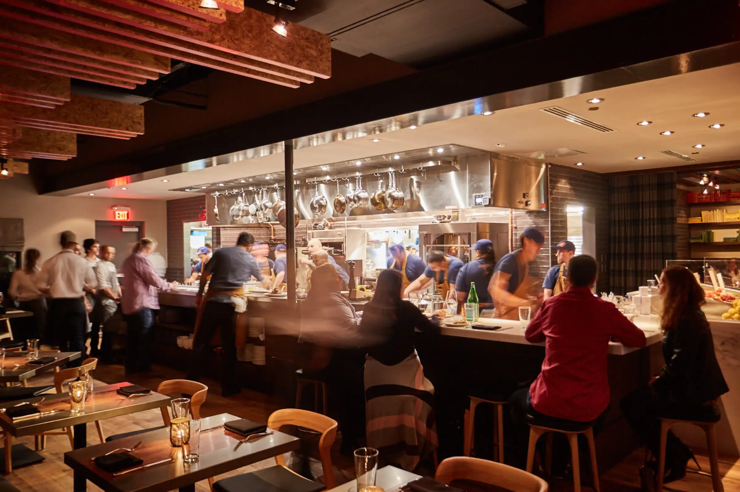 a group of people standing around a table in a restaurant