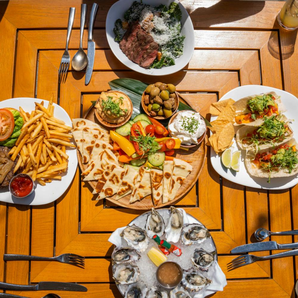 Some of The Pool House Lunch Favorites, Including the Baja Fish Tacos, Mezze Platter, and fresh oysters