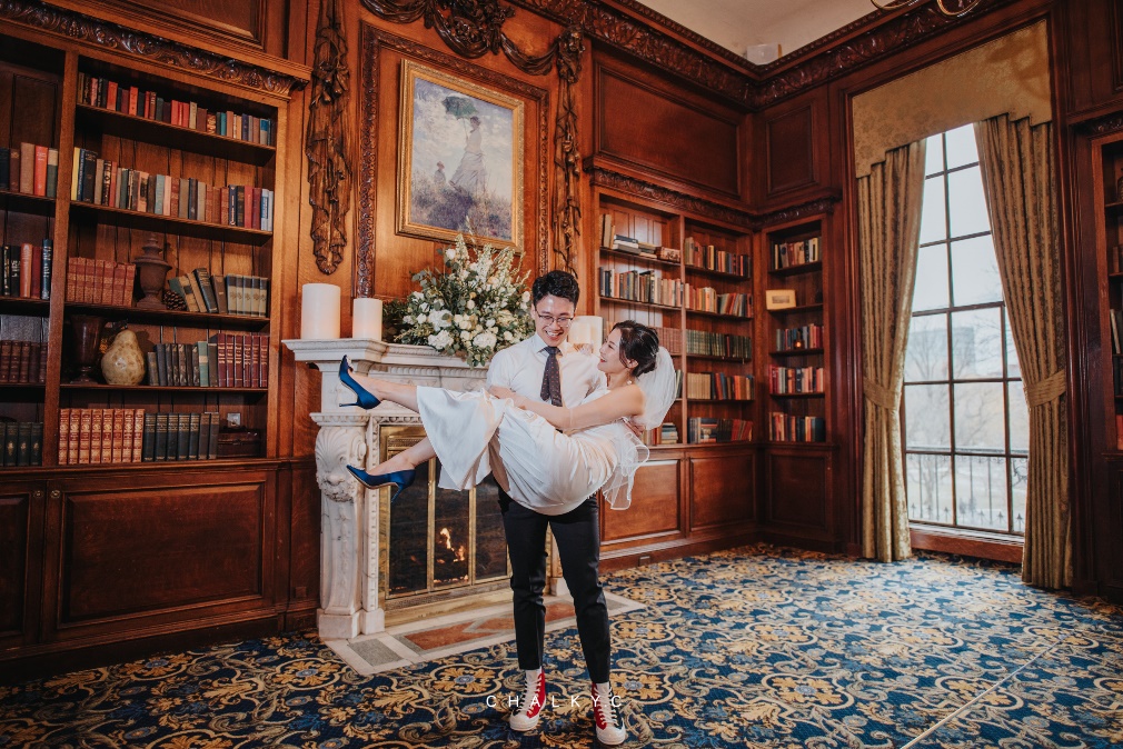 Newly engaged and excited to celebrate, the bride and groom capture a few fun shots in front of the stunning marble fireplace in our Grand Library.