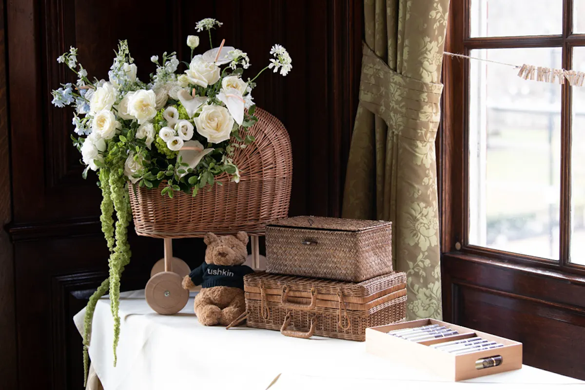 a basket of flowers and a teddy bear on a table