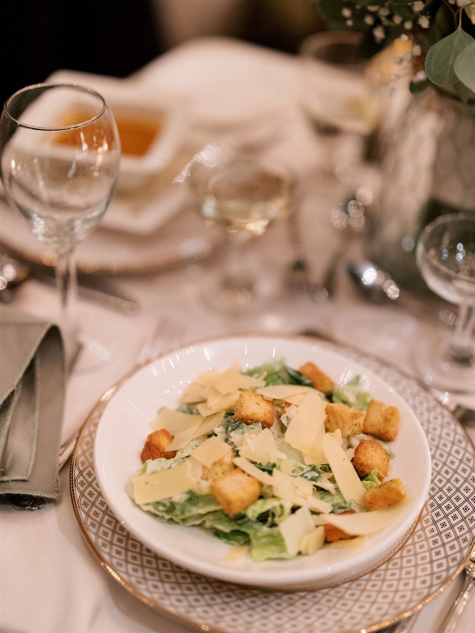 a plate of food and glasses of wine on a table