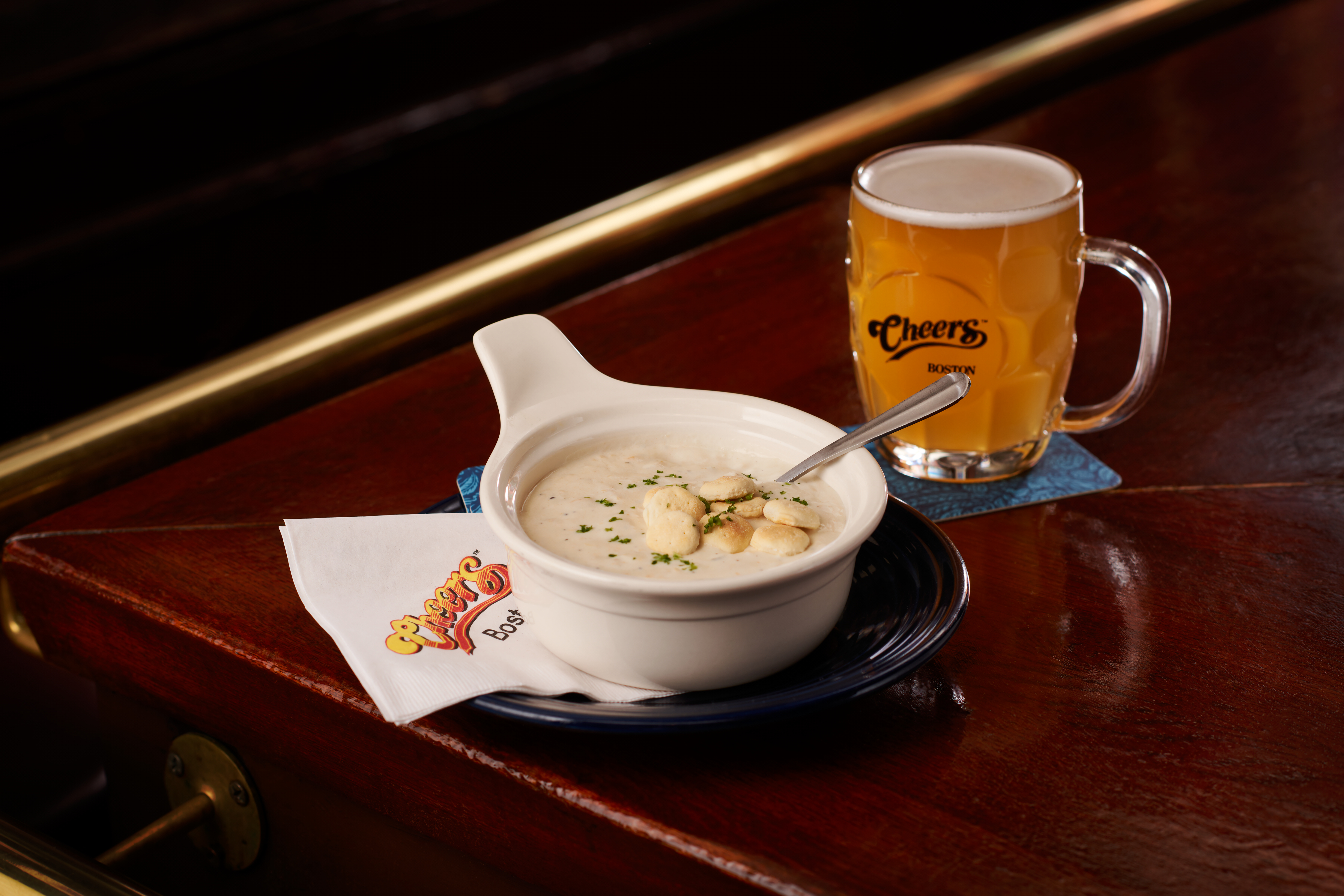 a bowl of soup and a beer on a table