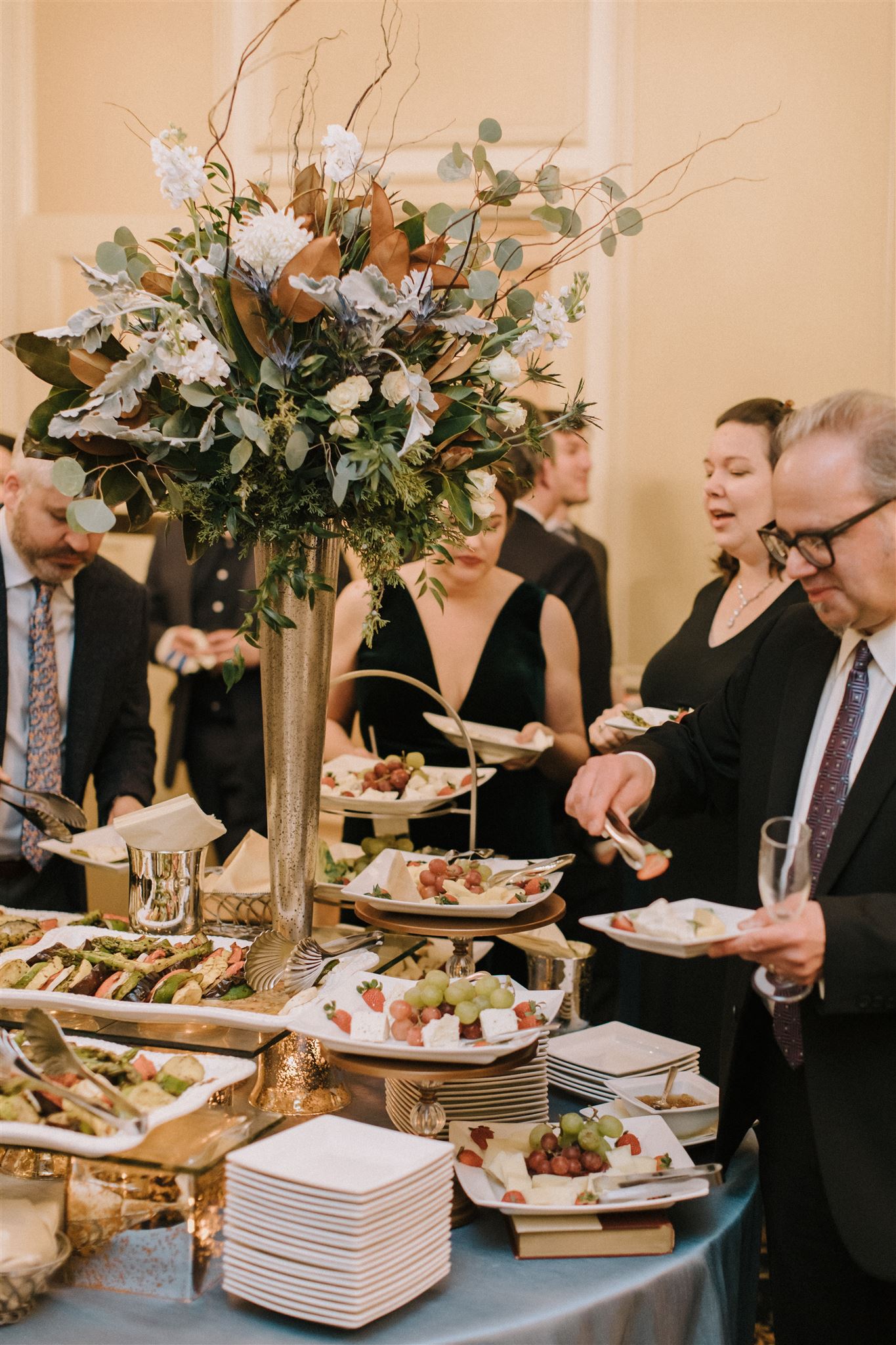 a group of people standing around a table eating food