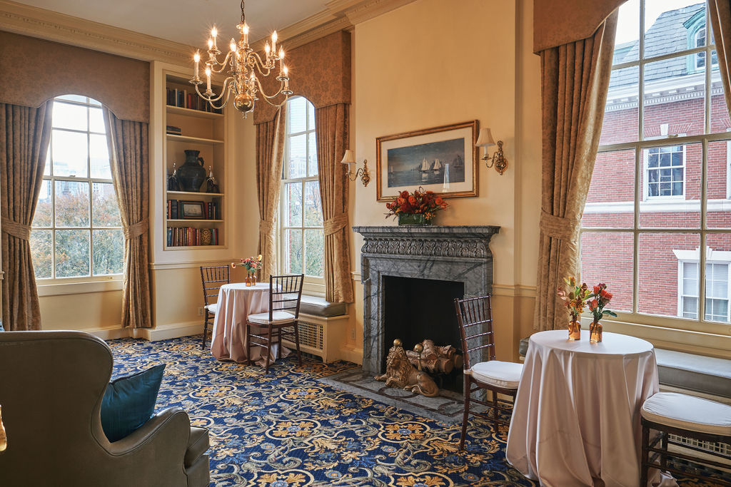 a room with small tables and a fireplace