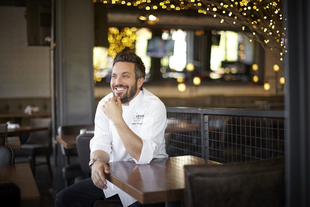 Fabio Viviani sitting at a table in a restaurant