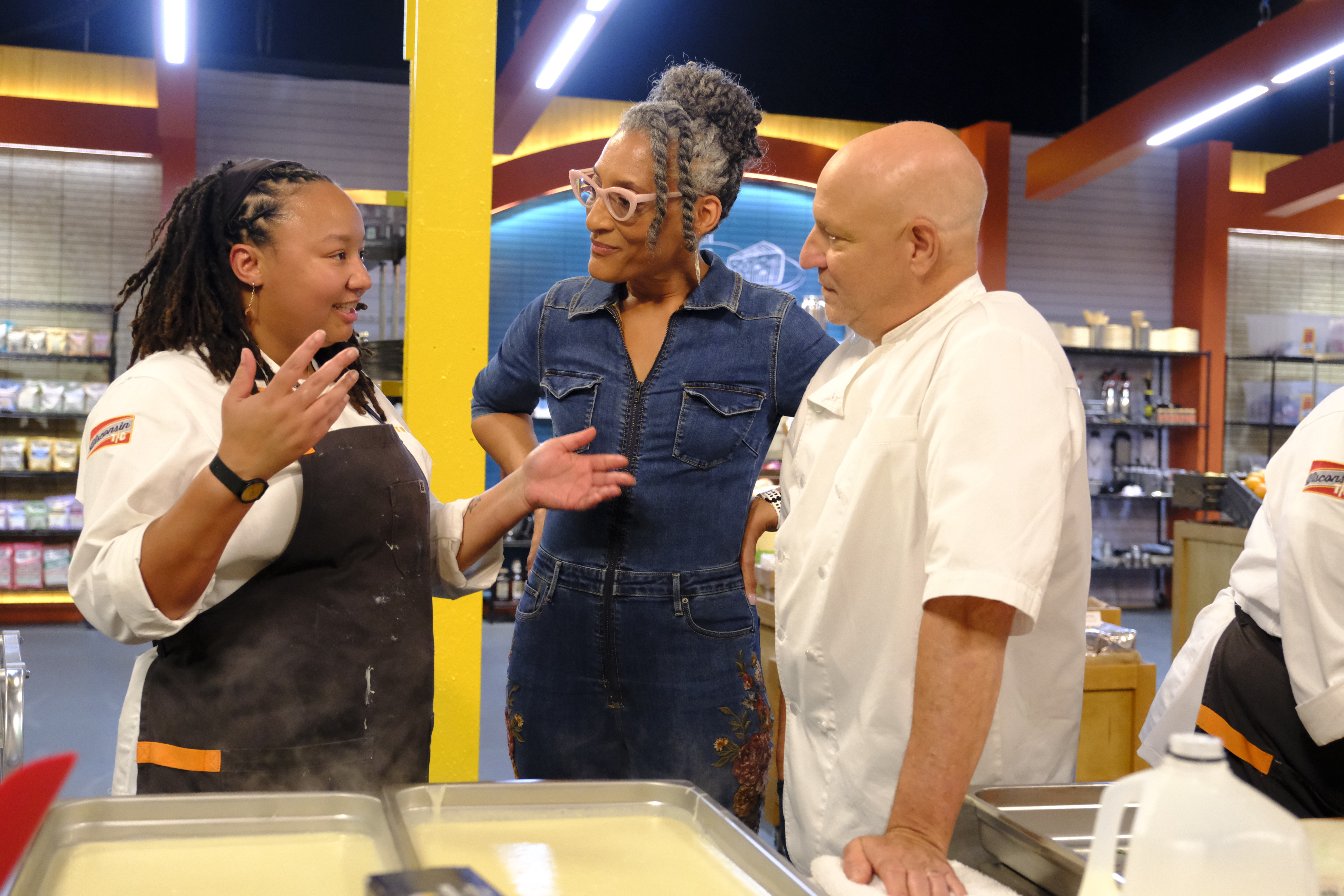 a group of people standing in front of a cake