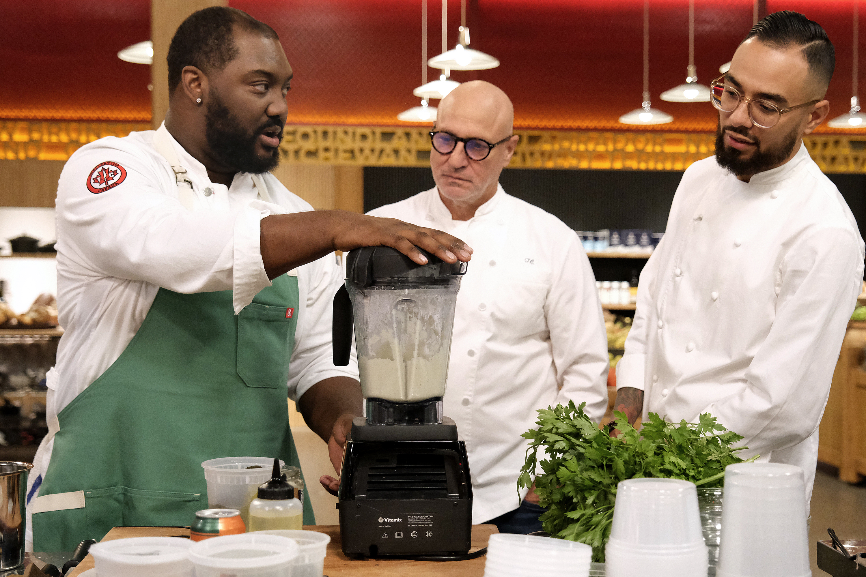 Tom Colicchio et al. that are standing in the kitchen