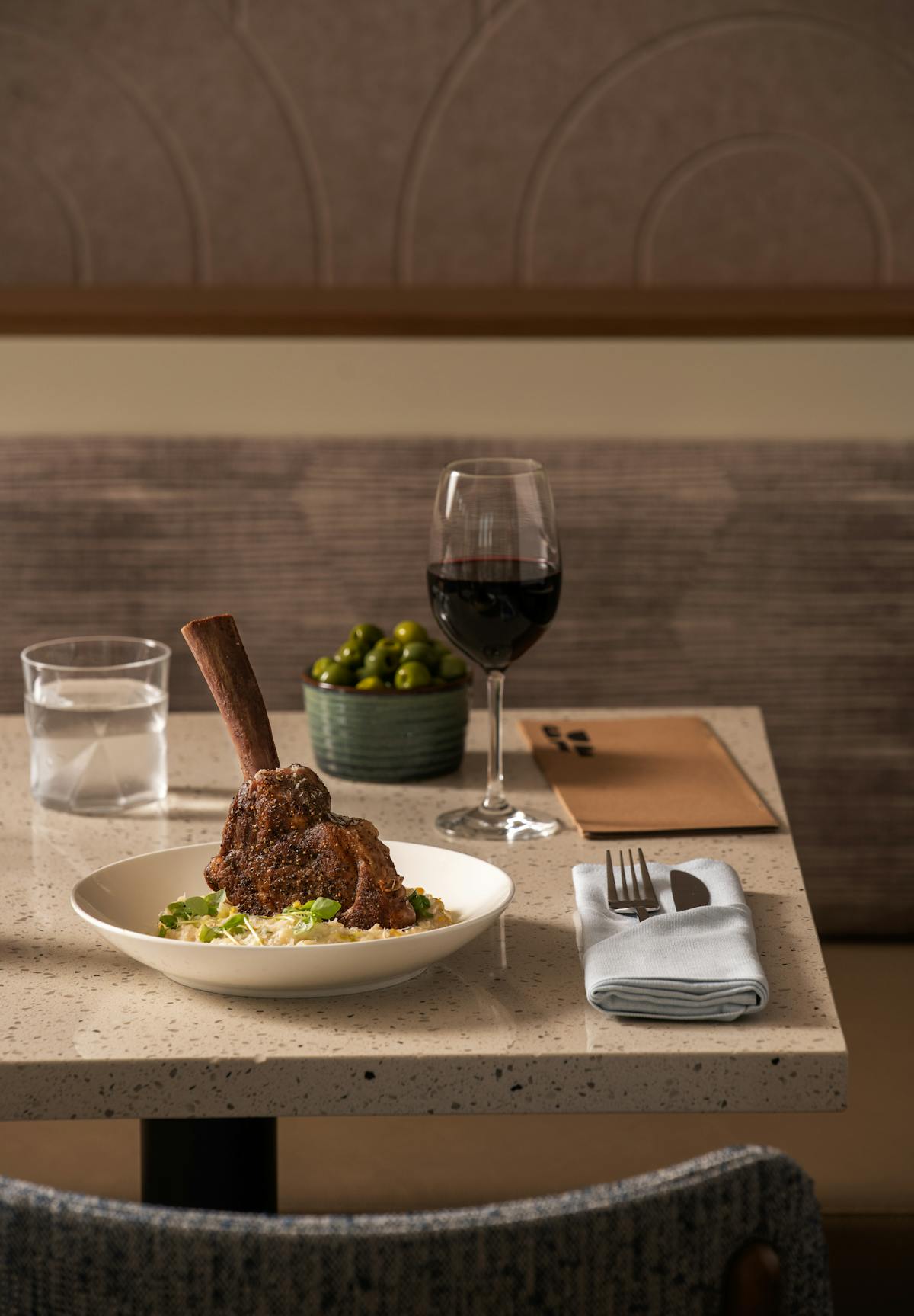 a plate of food and glasses of wine sitting on top of a table