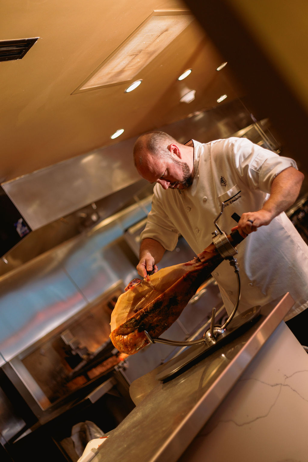 a man in a chef's uniform pouring meat into a large piece of meat