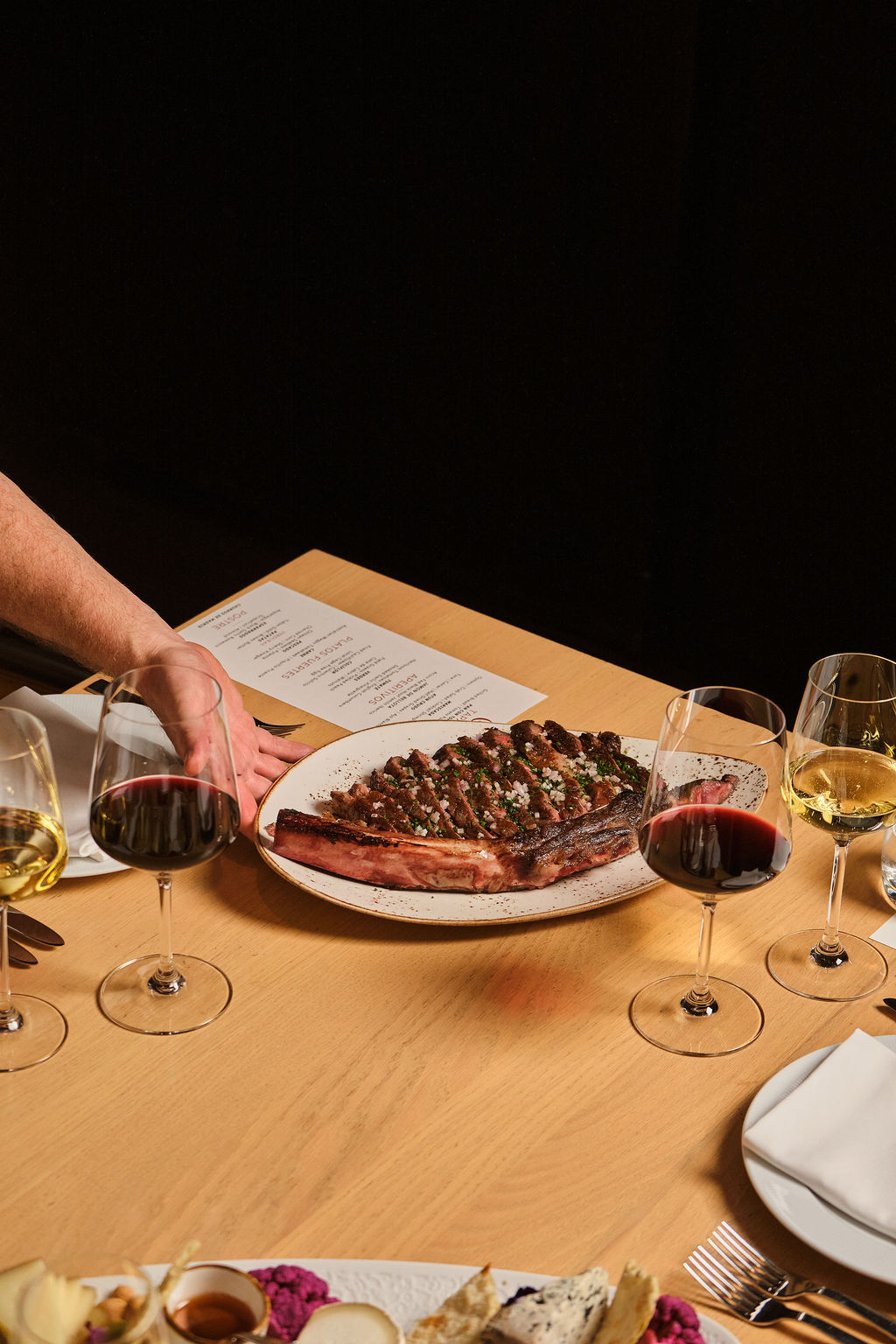 a plate of meat and wine glasses on a table