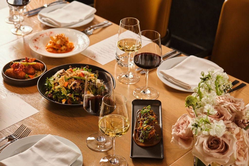 a table with food and wine glasses