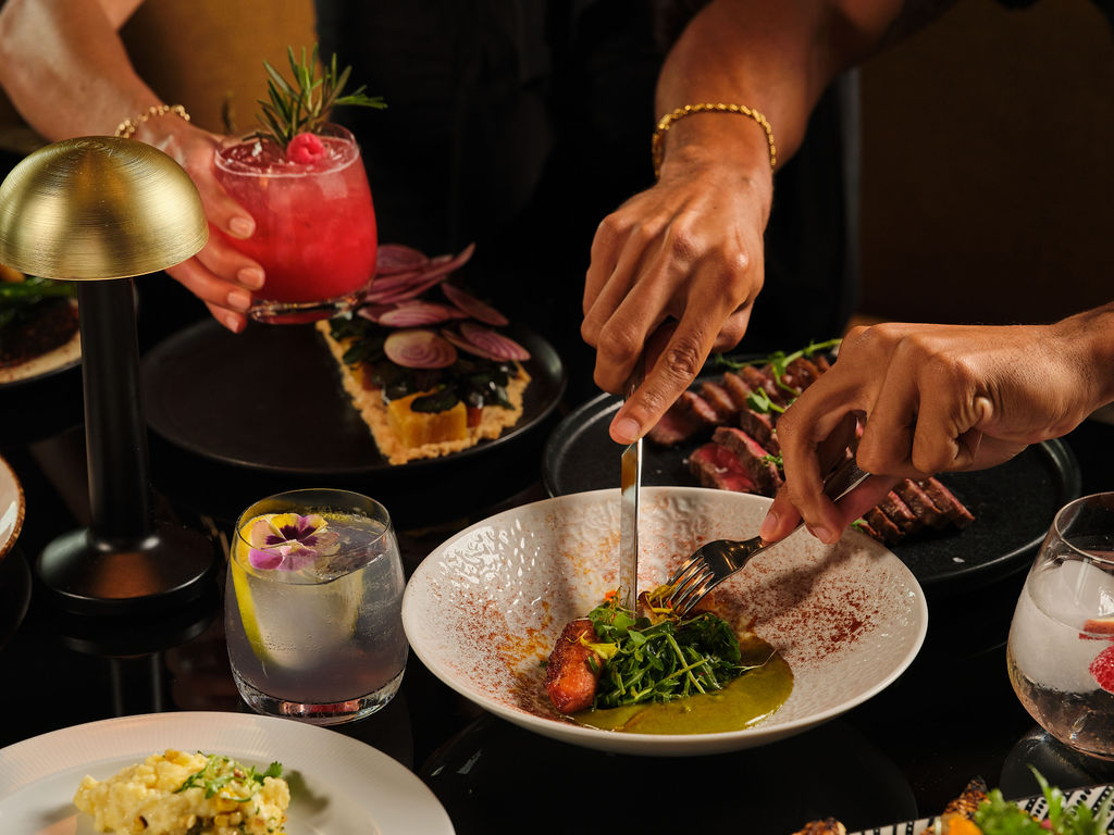 a man holding a plate of food on a table