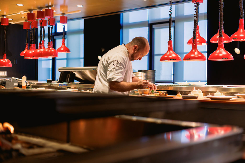 a man in a chef's uniform preparing food in a kitchen