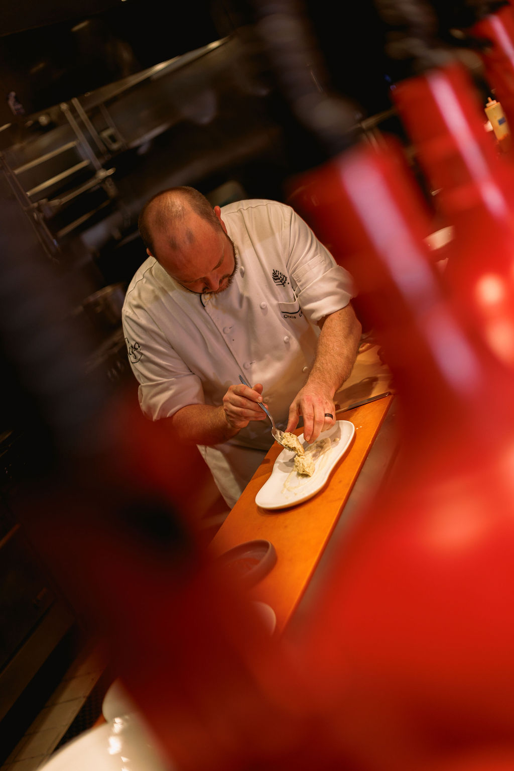 a man in a chef's uniform cutting food