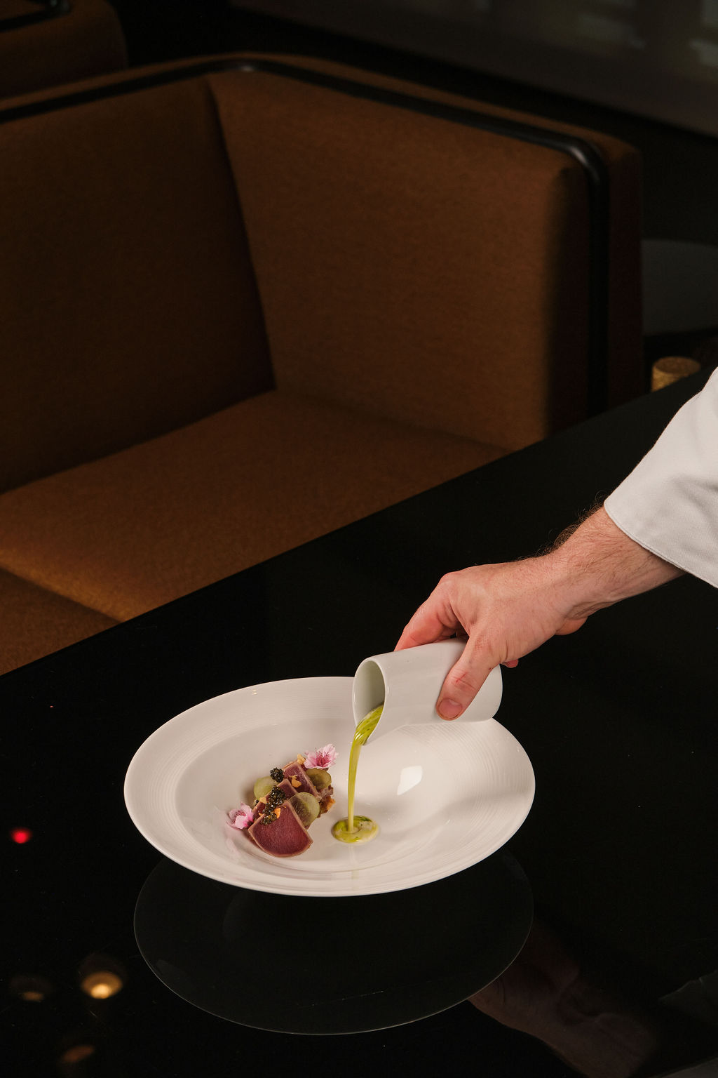a person holding a plate of food on a table