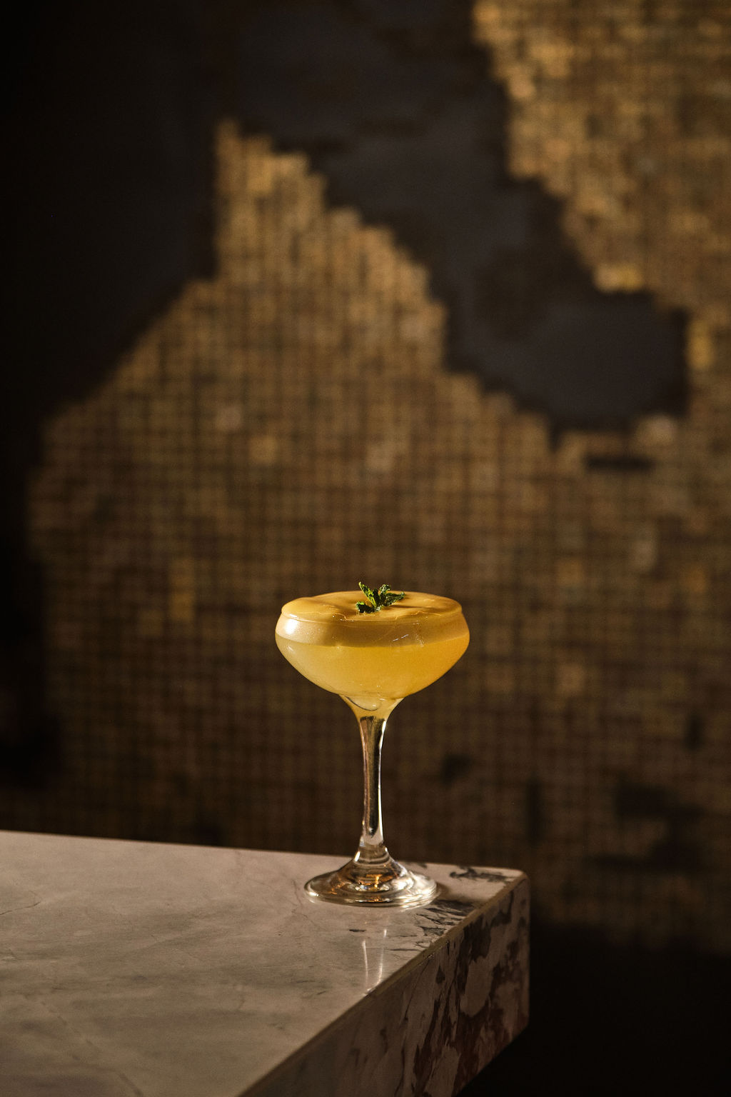 a glass with a drink on a counter
