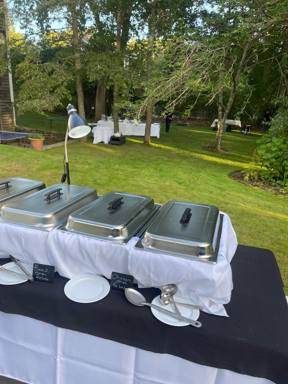a group of people sitting at a table in a park
