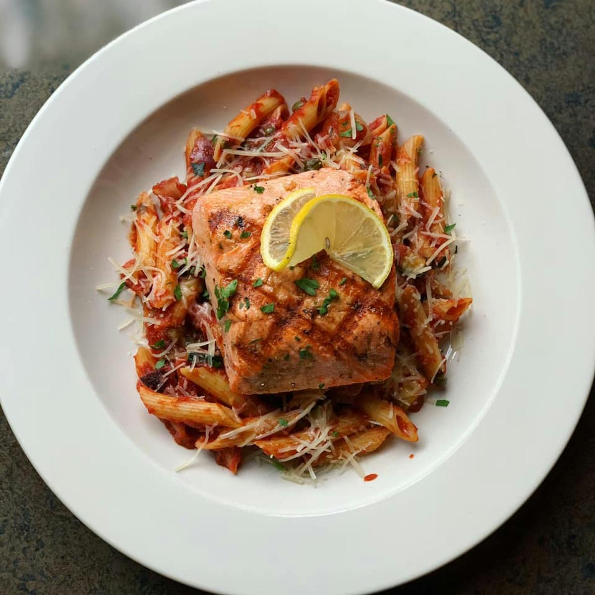 Grilled salmon over penne pasta