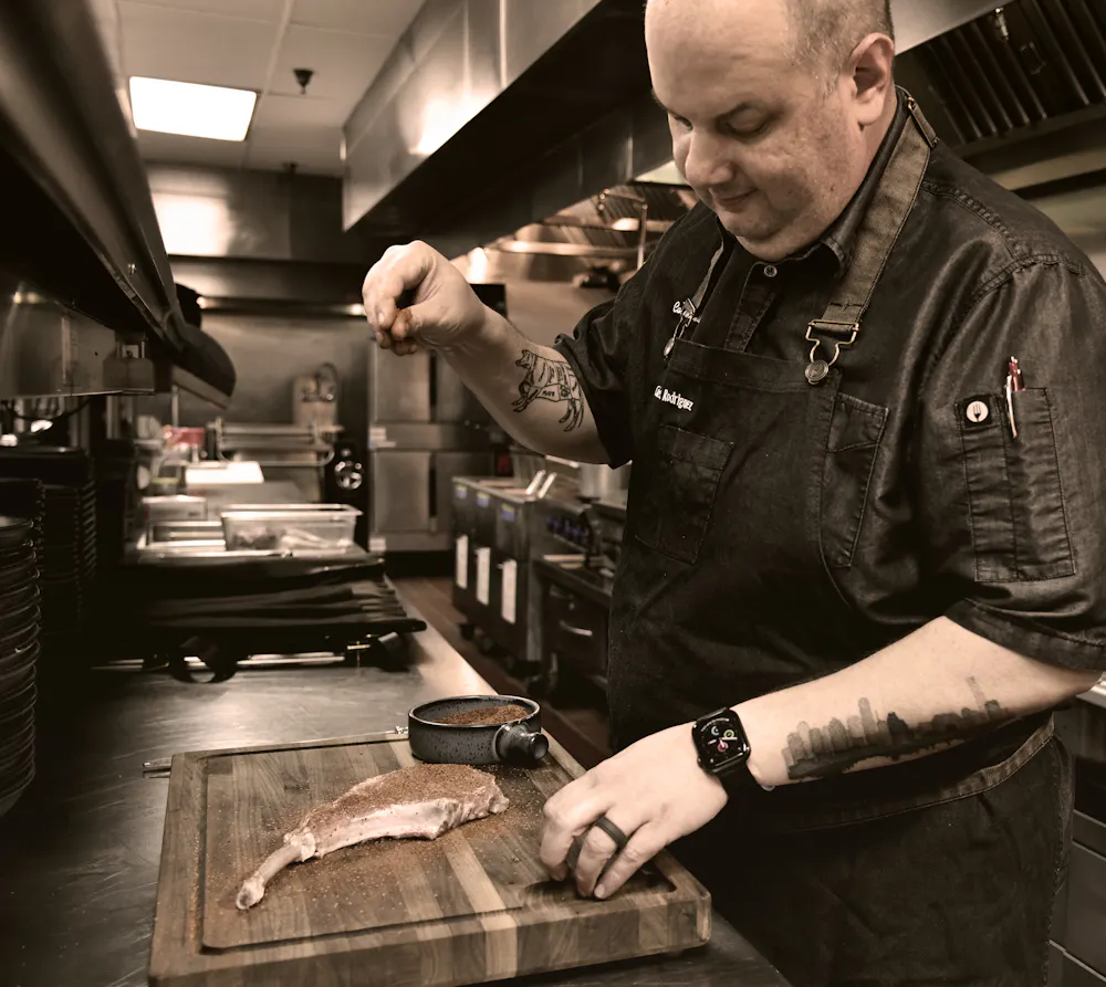 a man standing next to a knife on a cutting board