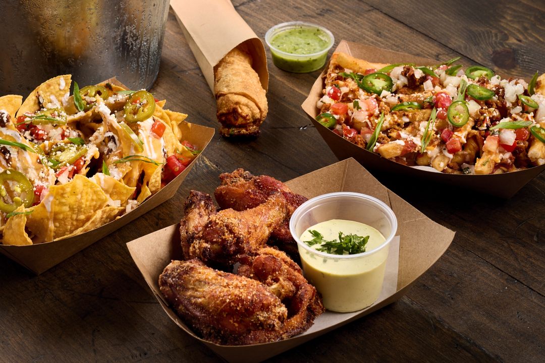Group shot of food items found on the happy hour menu at taco bamba including chicken wings, nachos, loaded fries and more