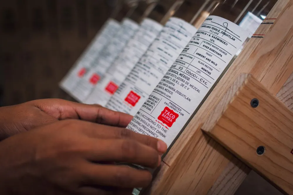 Process of labeling Rey Campero exclusive Taco Bamba private label mezcal with a Taco Bamba logo on the back.