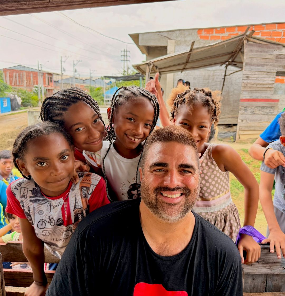 Chef Victor Albisu posing with a group of children while on a trip with Smile on the World, a charity of chefs and doctors that bring aid to underserved communities