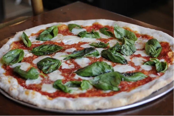 a pizza sitting on top of a wooden table