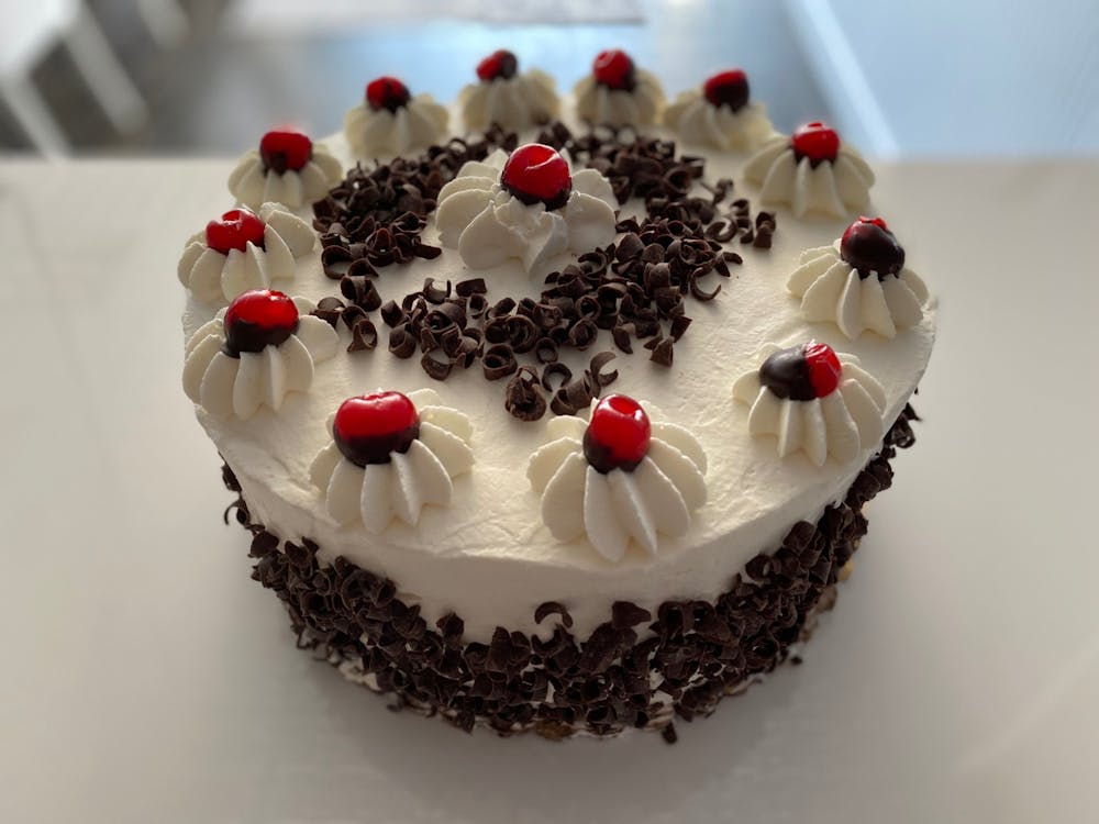 a birthday cake made to look like a train with Black Forest in the background