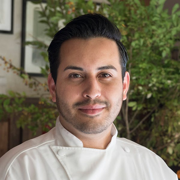 a man wearing a white shirt and smiling at the camera