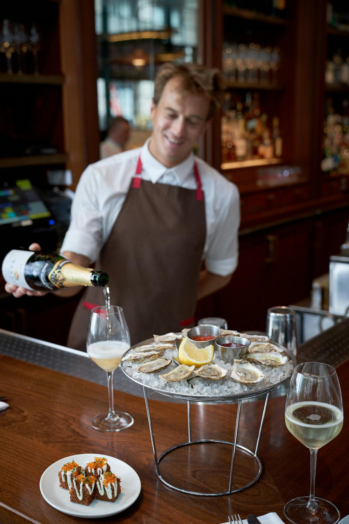 a bartender serving drinks with oysters