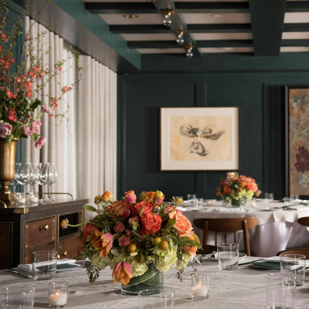 a room filled with furniture and vase of flowers on a table