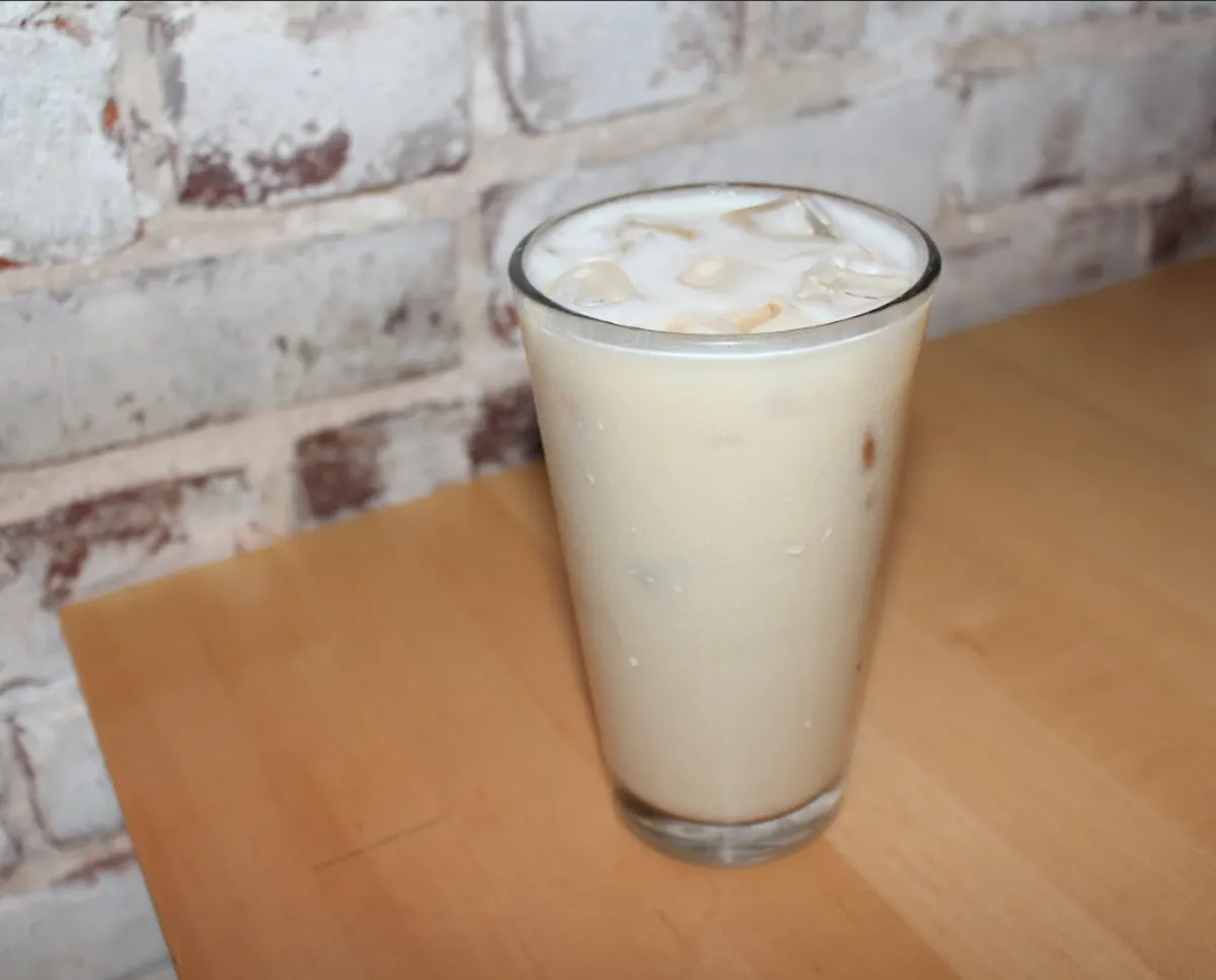 a glass of milk with ice on a table