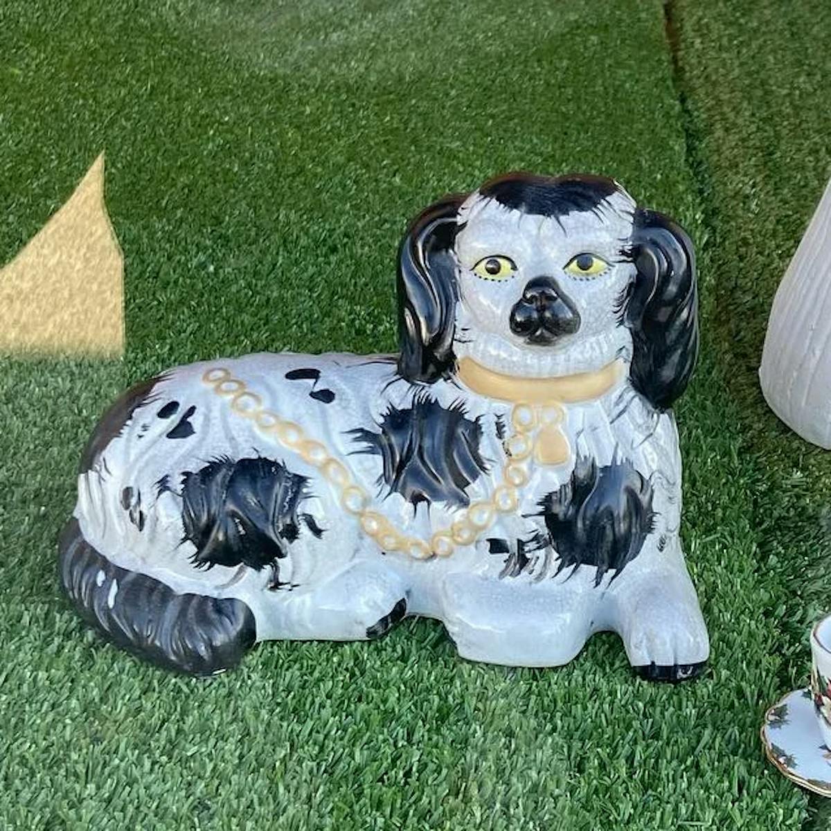 a dog sitting on top of a grass covered field