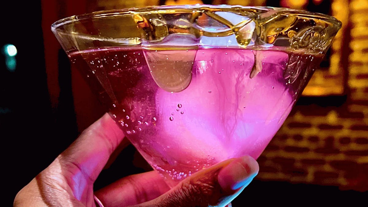 close up of a sparkling purple lavender infused champagne cocktail served in a honey rimmed martini glass at Better Than Sex - A Dessert Restaurant