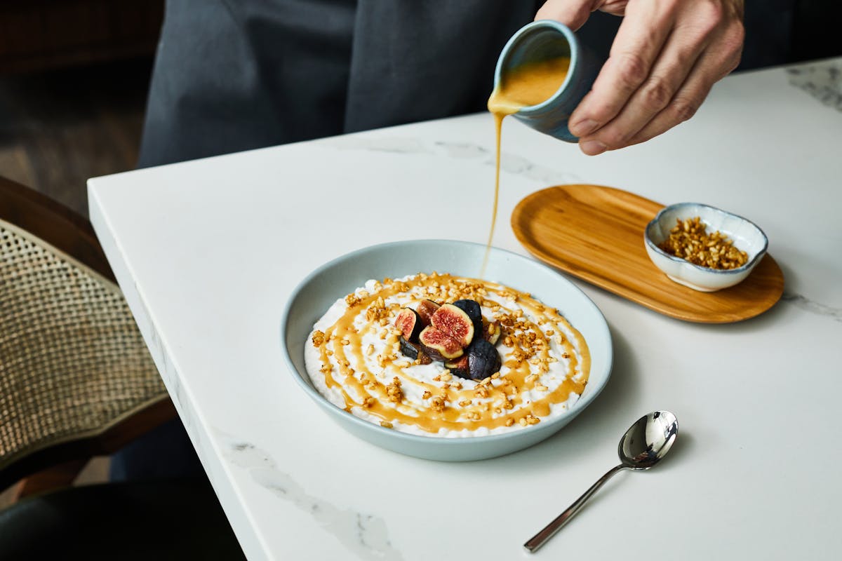 a person sitting at a table with a plate of food