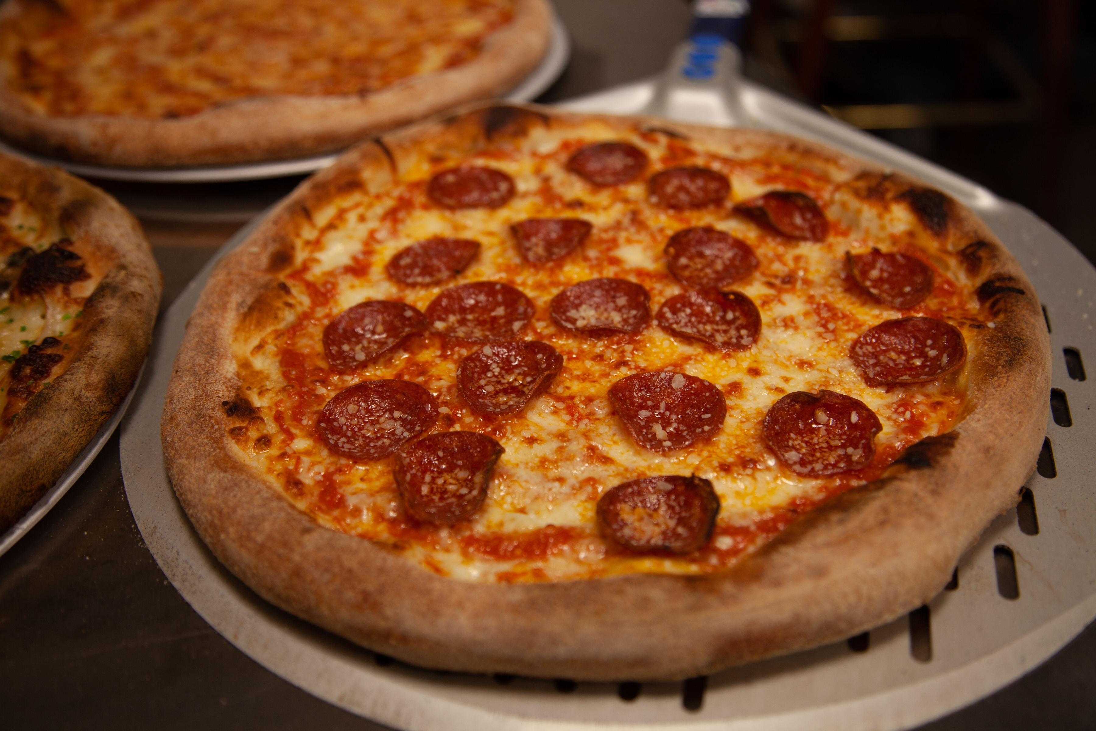a pepperoni pizza sitting on top of a pan on a table