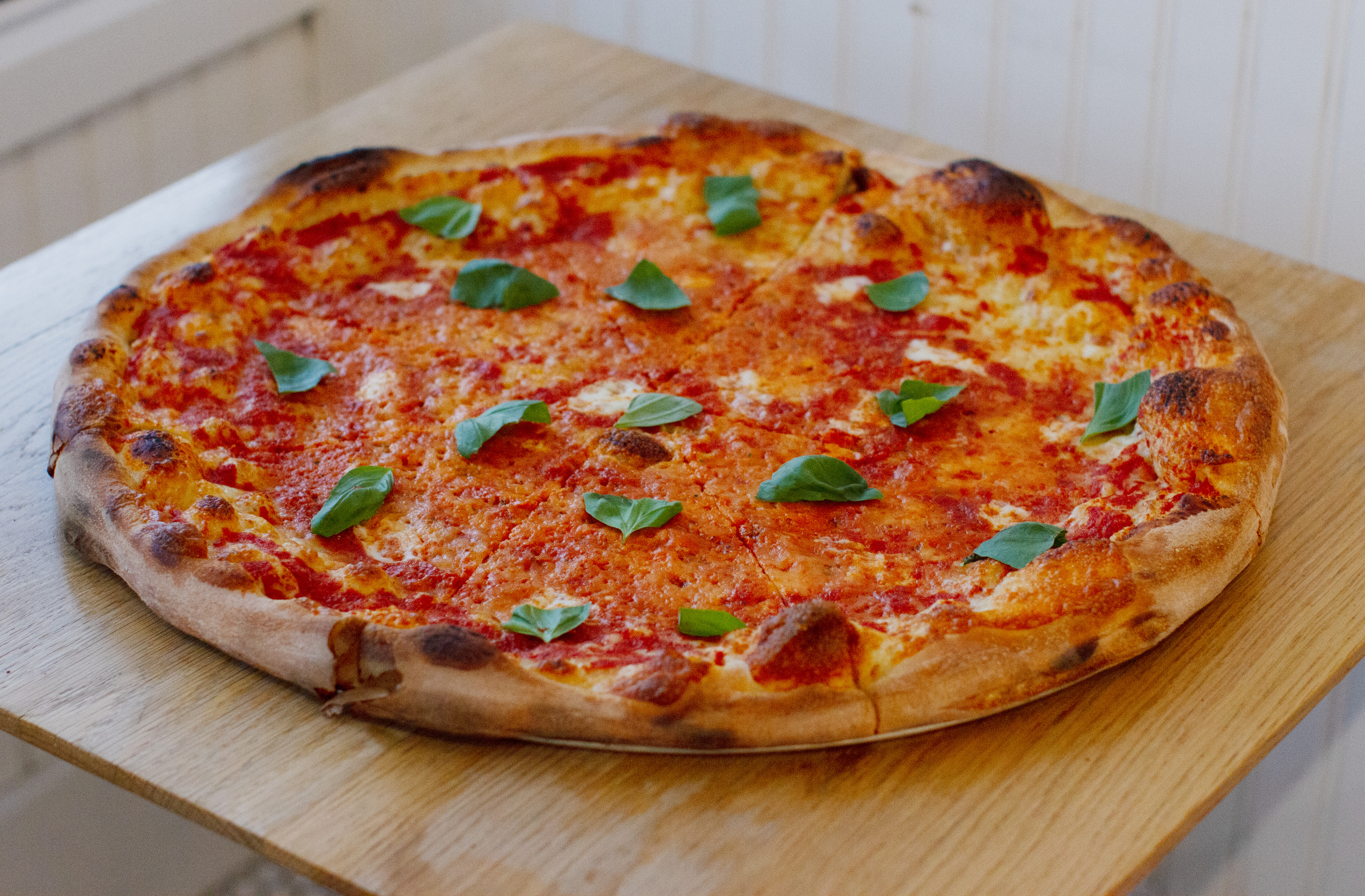 a pizza sitting on top of a wooden cutting board