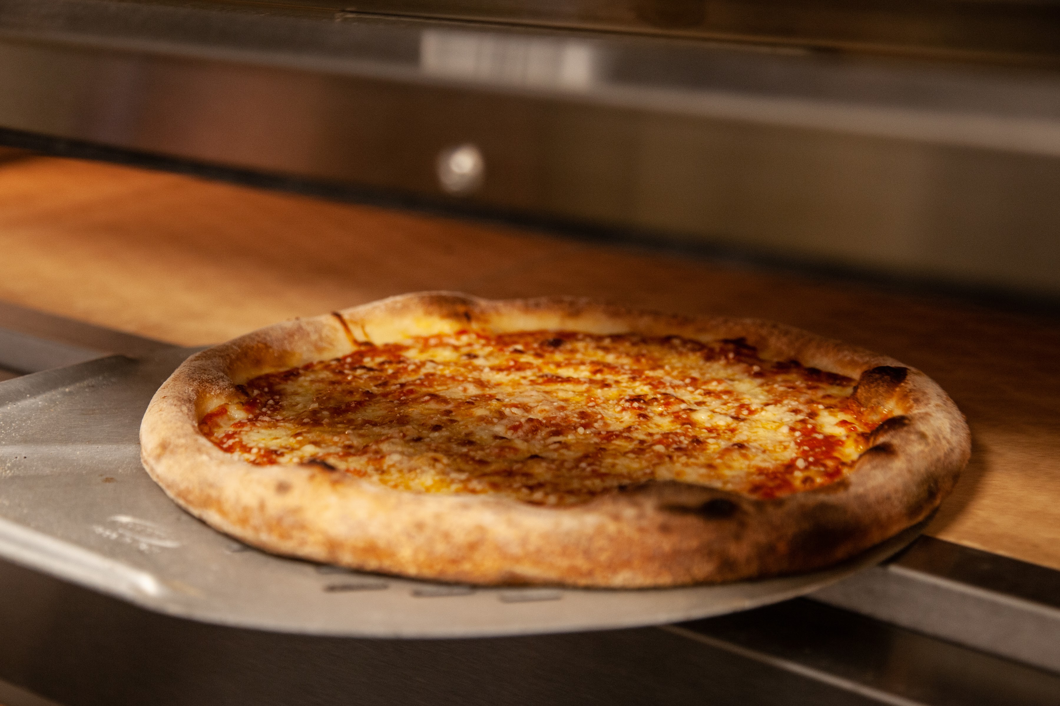 a pizza sitting on top of a wooden table