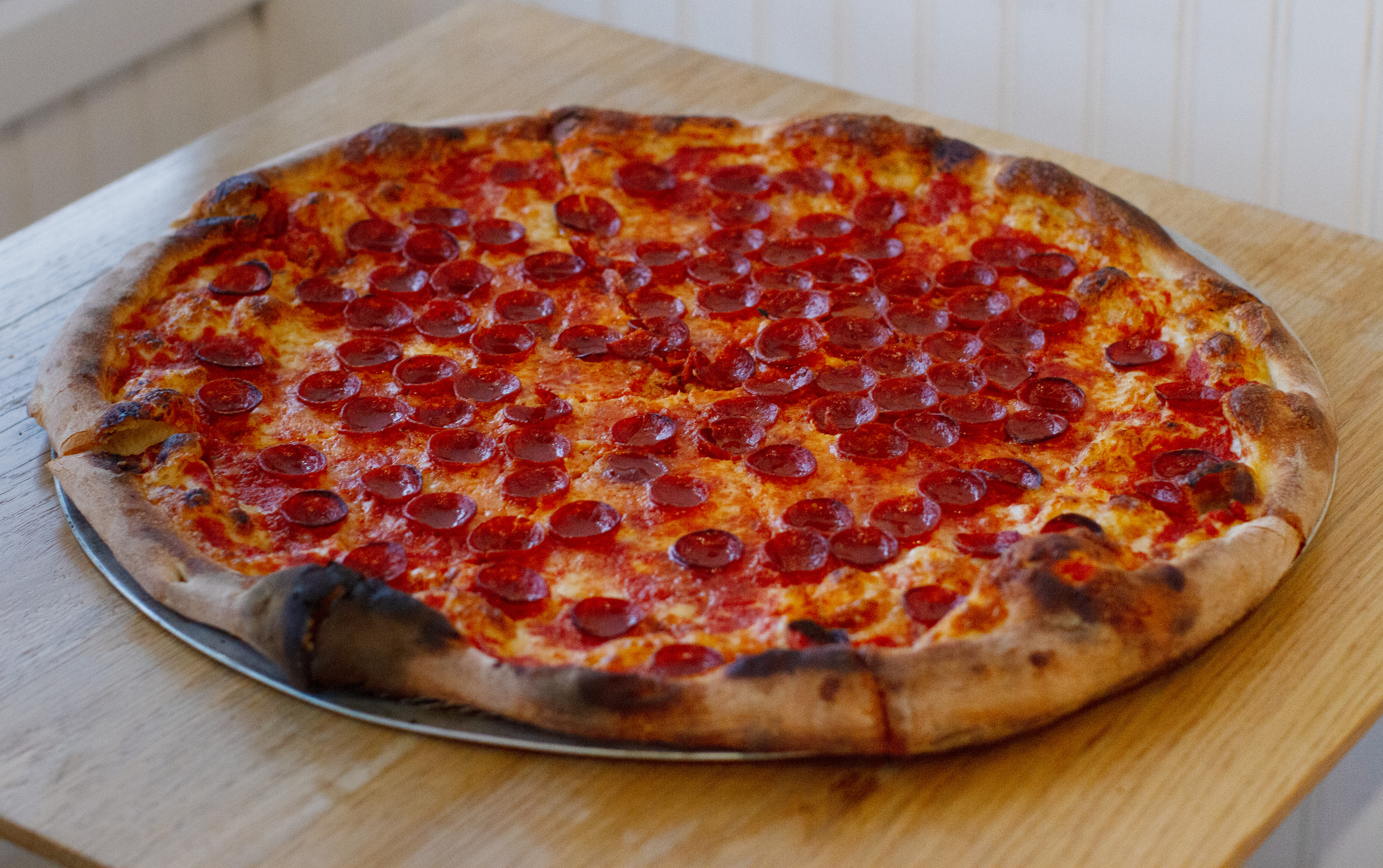 a pizza sitting on top of a wooden cutting board