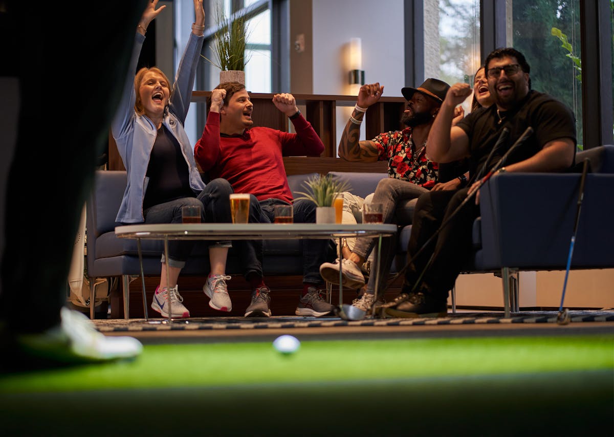 Friends gathered on a couch at 1776 Morristown, sharing joyful moments and engaging in lively conversation.
