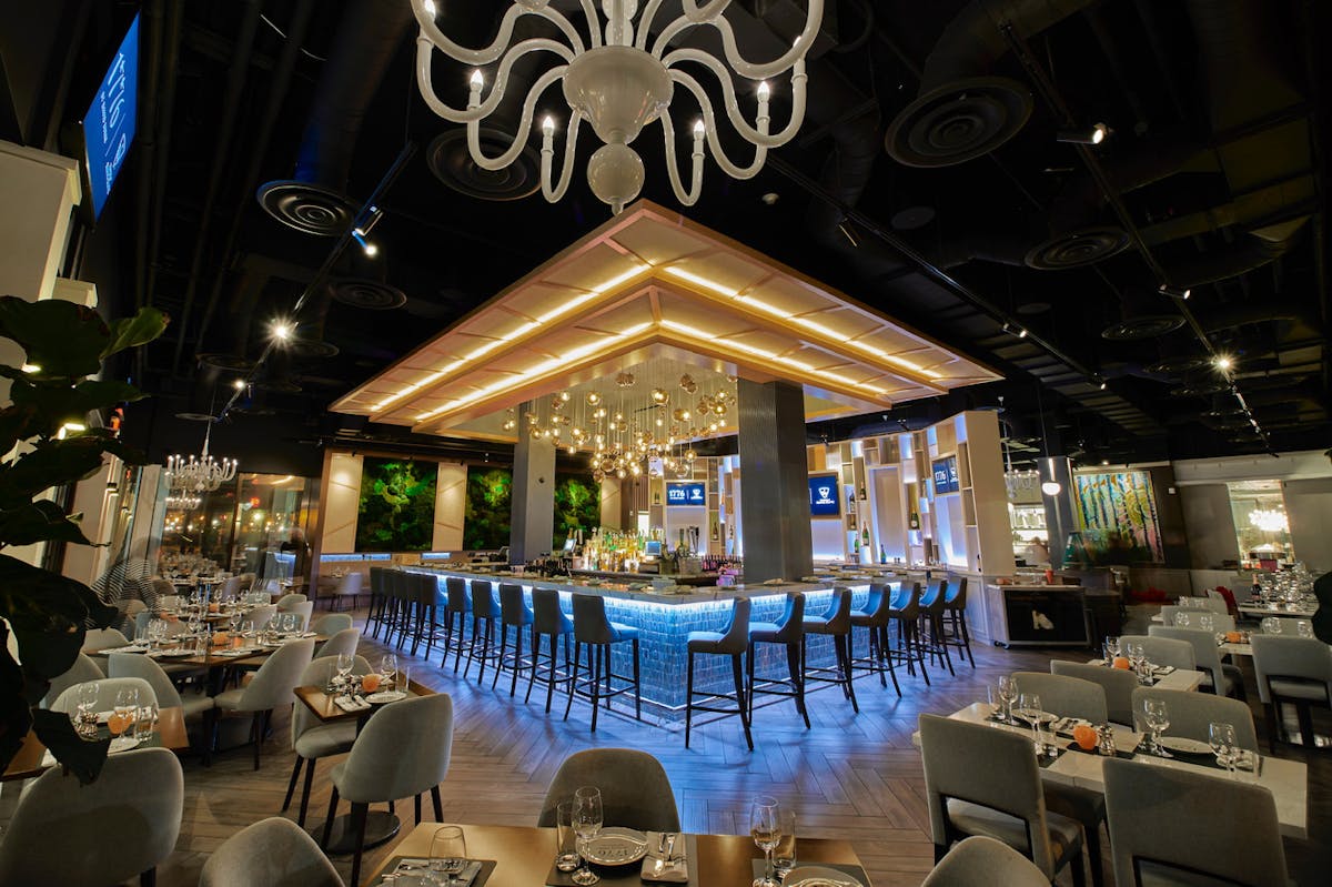 A cozy restaurant featuring a bar and neatly arranged tables for dining and socializing.