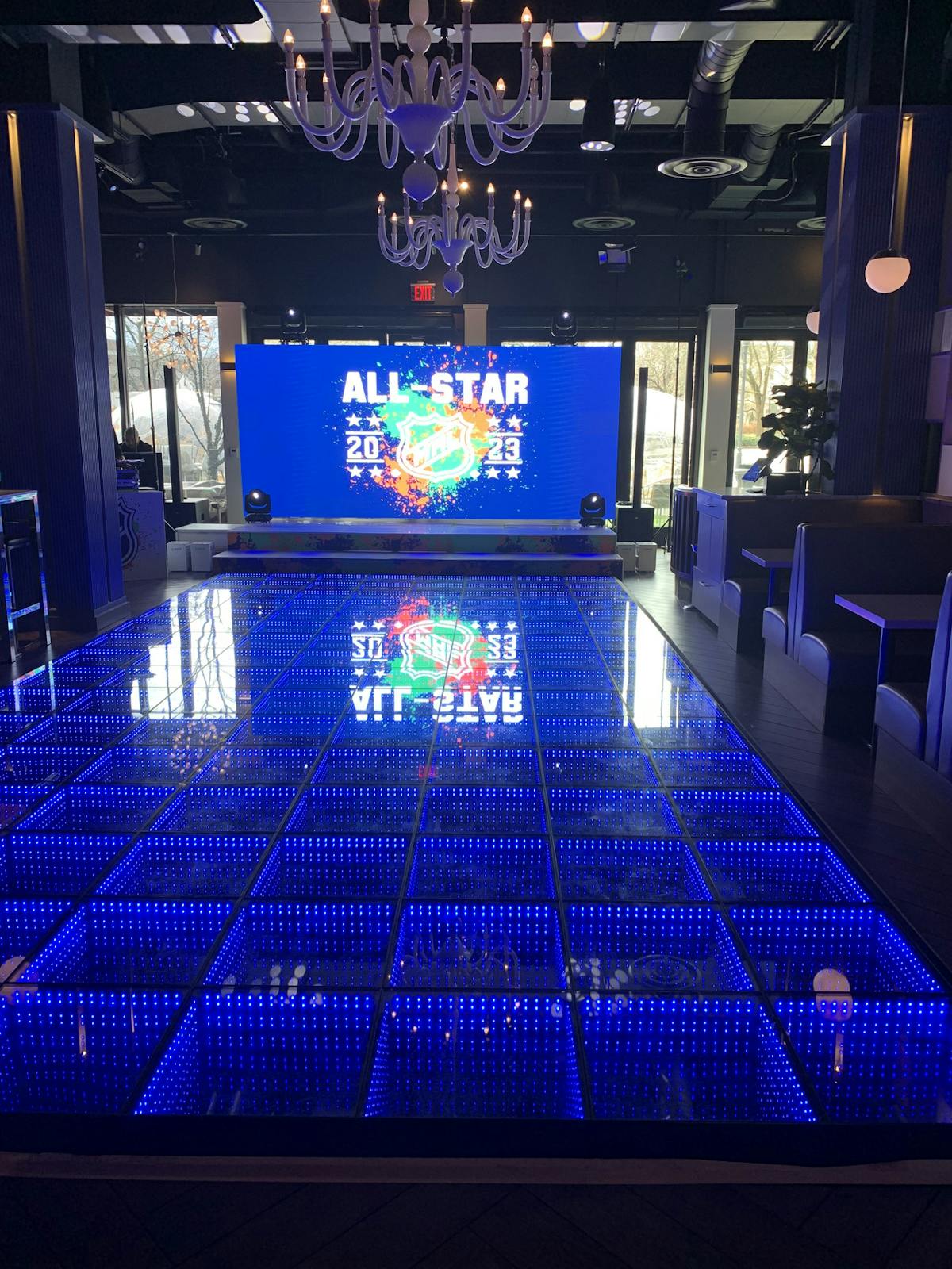 A spacious dance floor illuminated by vibrant blue lights, creating a lively atmosphere for dancing.