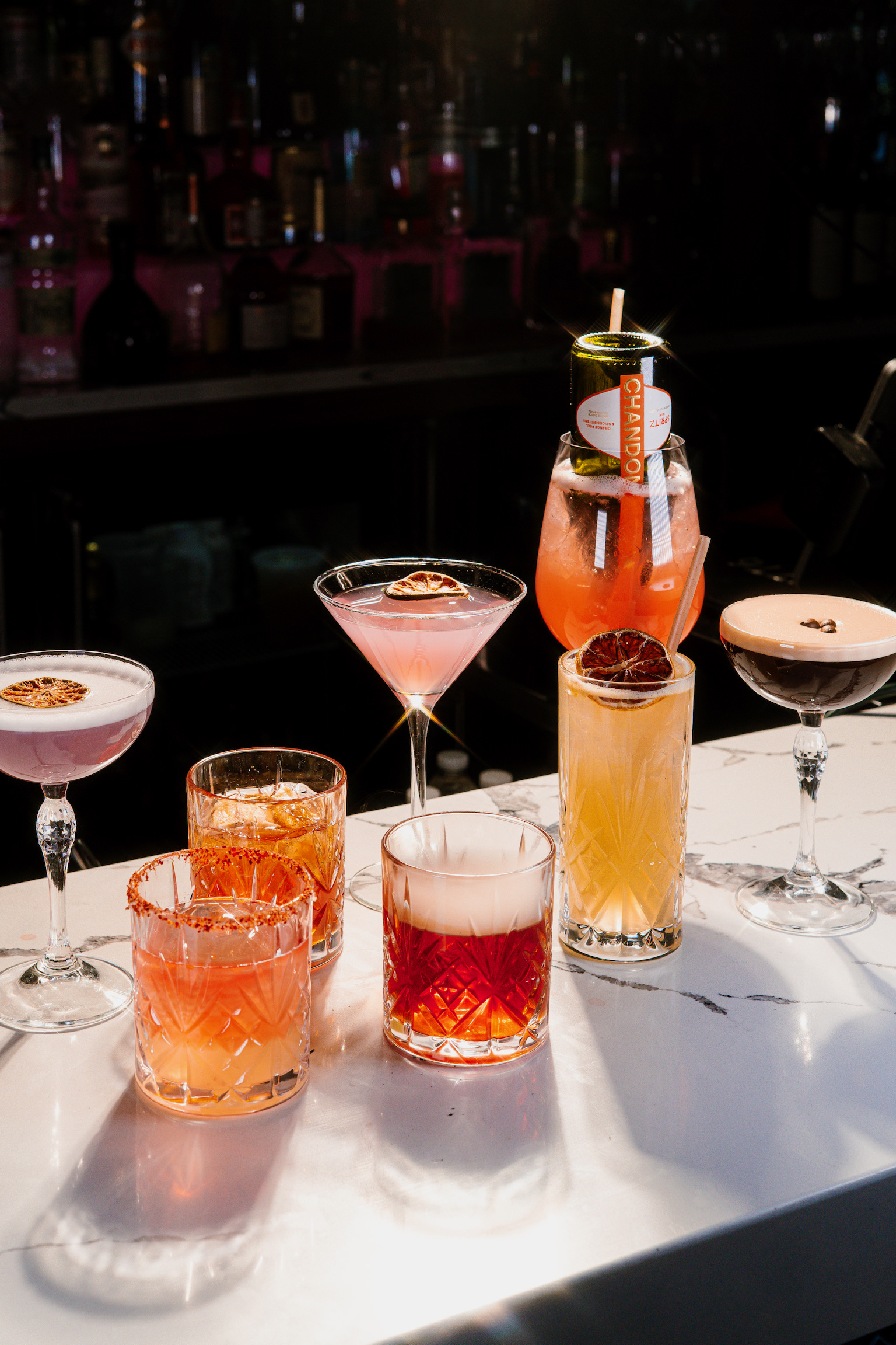 a group of different colored drinks on a table