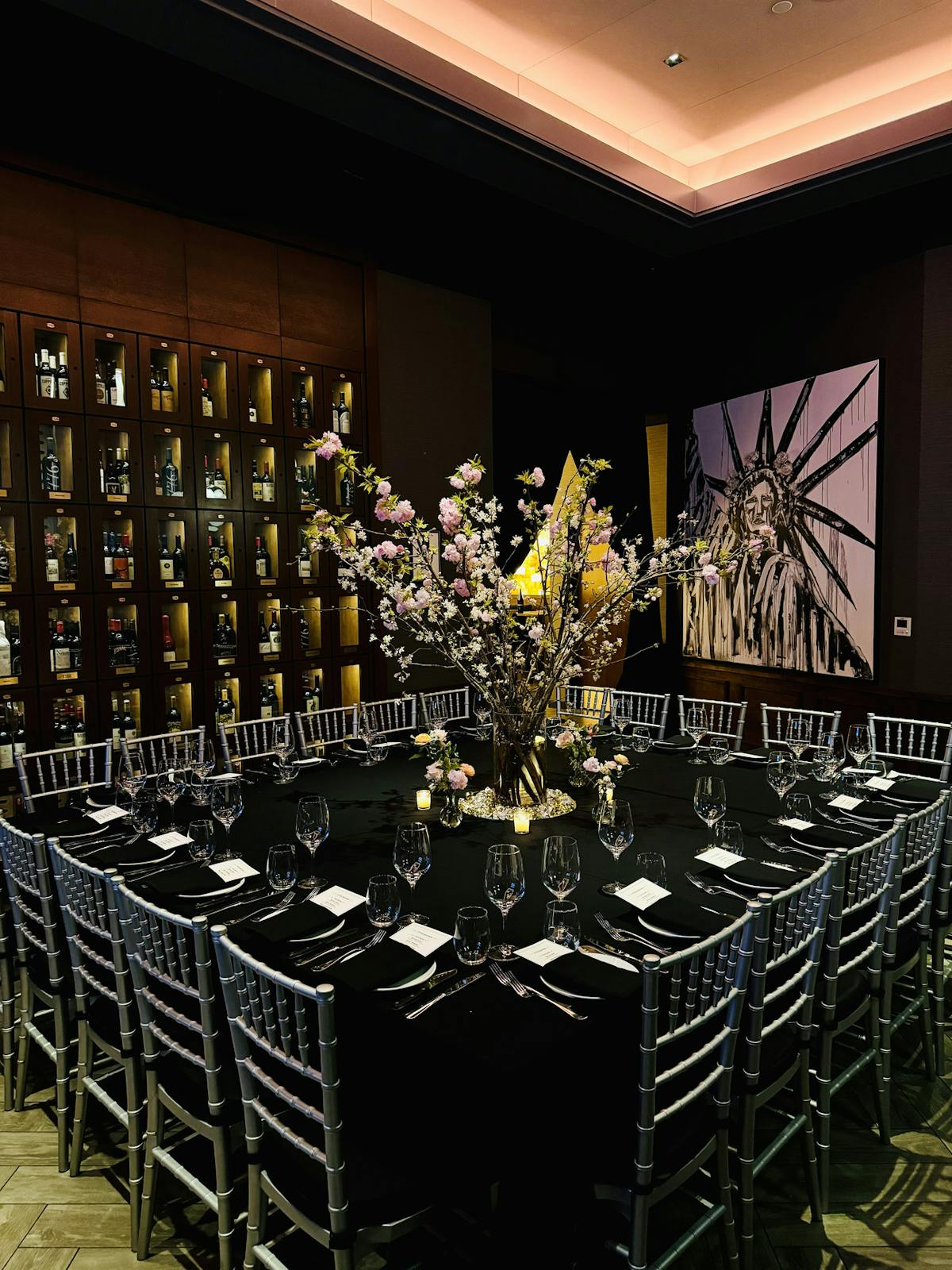A large dining table elegantly arranged with plates, cutlery, and decorative centerpieces for a dinner party.