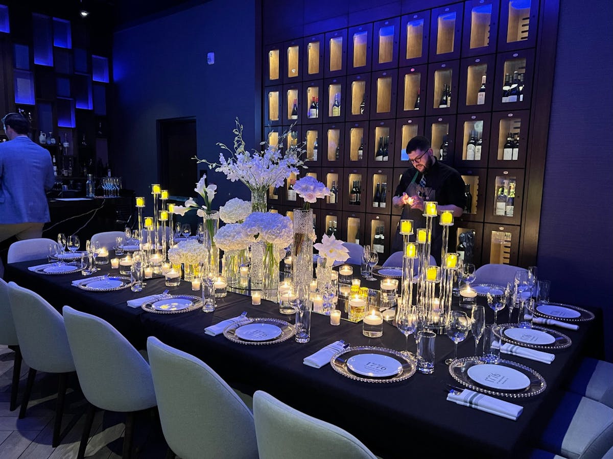 A table elegantly set with a black cloth and polished silverware, creating a sophisticated dining atmosphere.