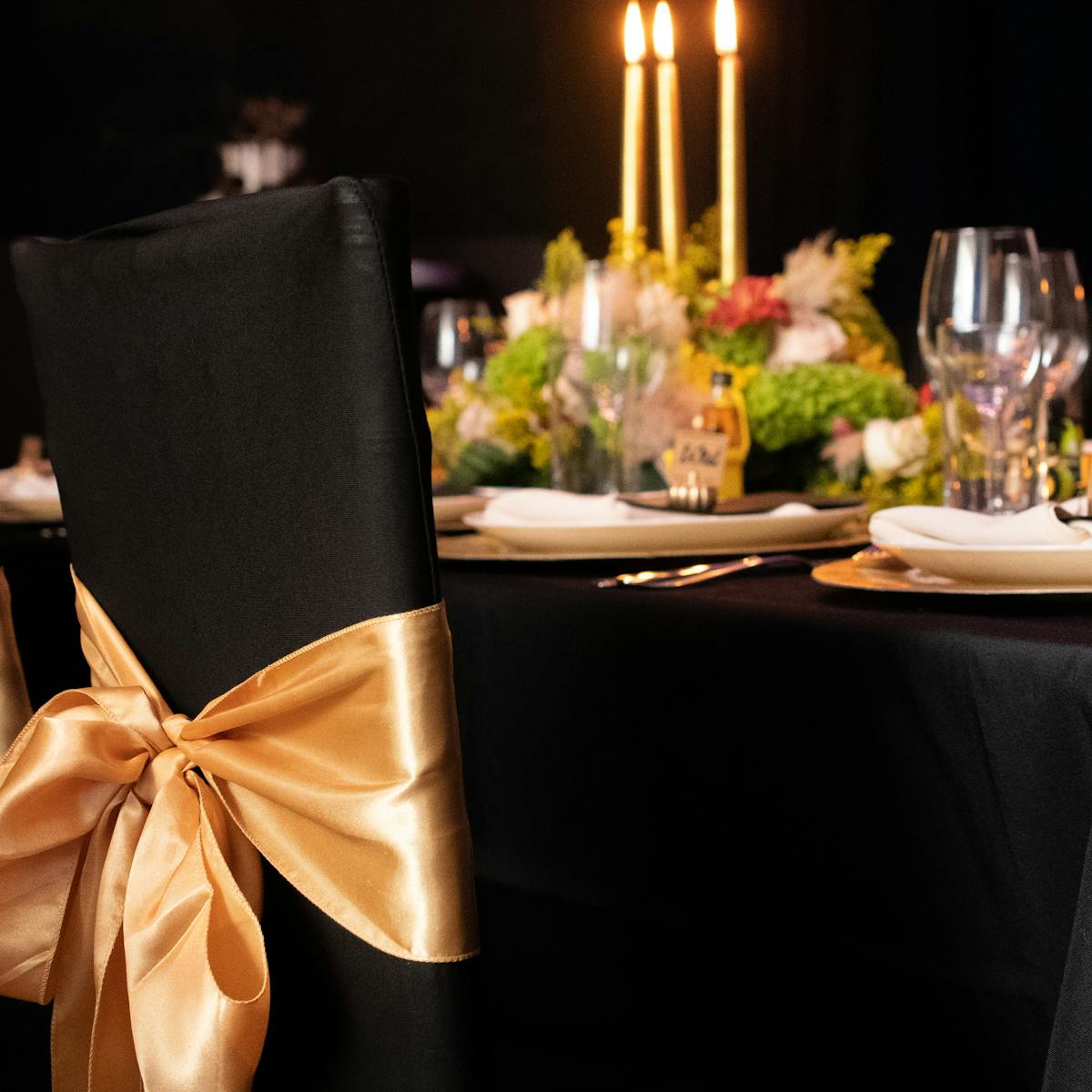 A modern black table paired with luxurious gold and black chairs, perfect for an upscale dining experience.