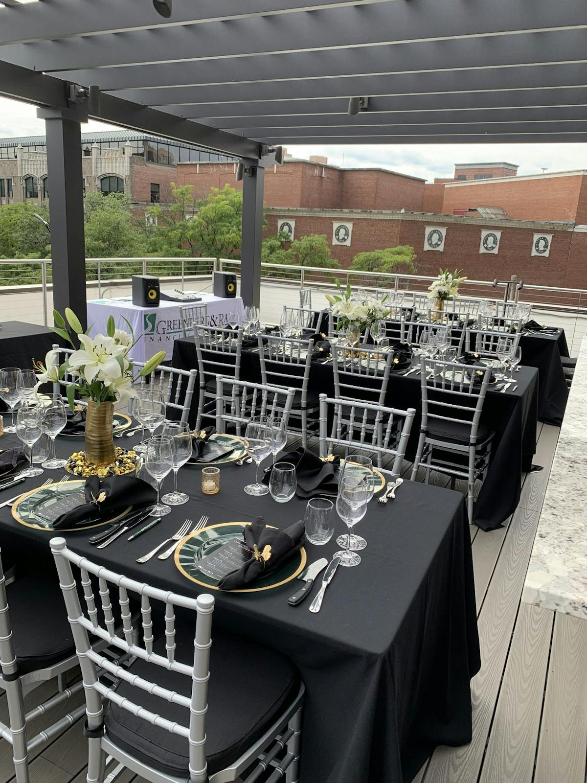 A rooftop table elegantly dressed with black and white tablecloths, ready for a special gathering.