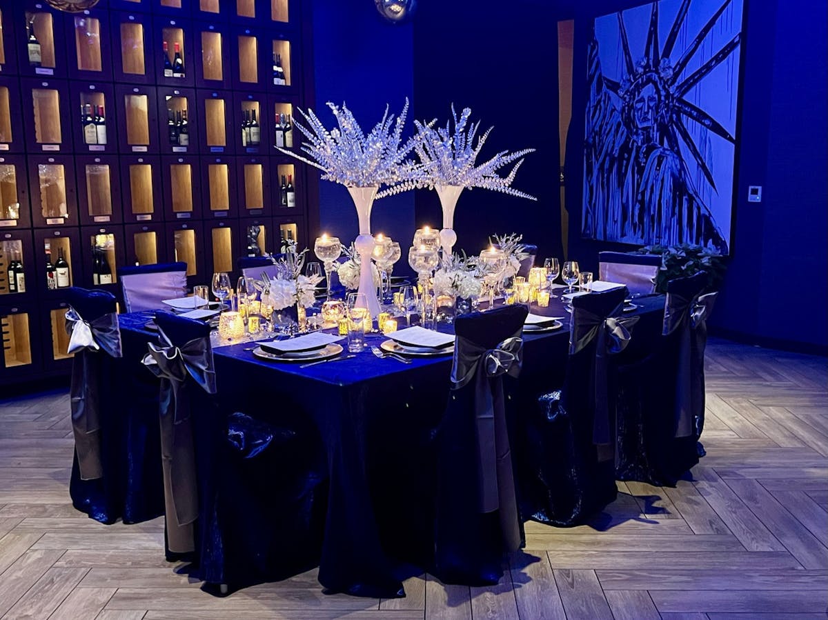 A beautifully arranged dinner table illuminated by soft blue lighting, creating an inviting atmosphere for guests.