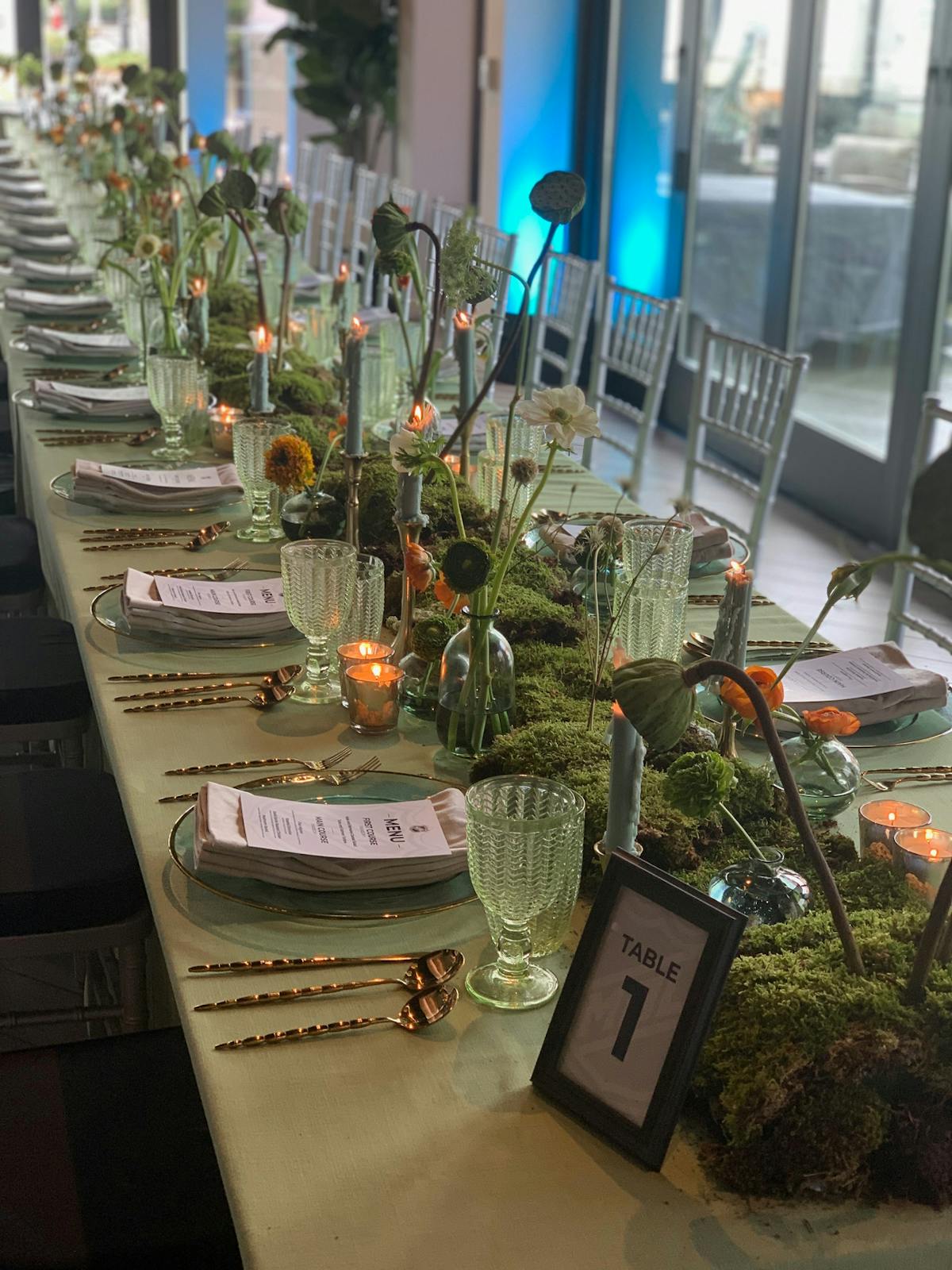 long table covered with a flowing tablecloth, set for a gathering or event.