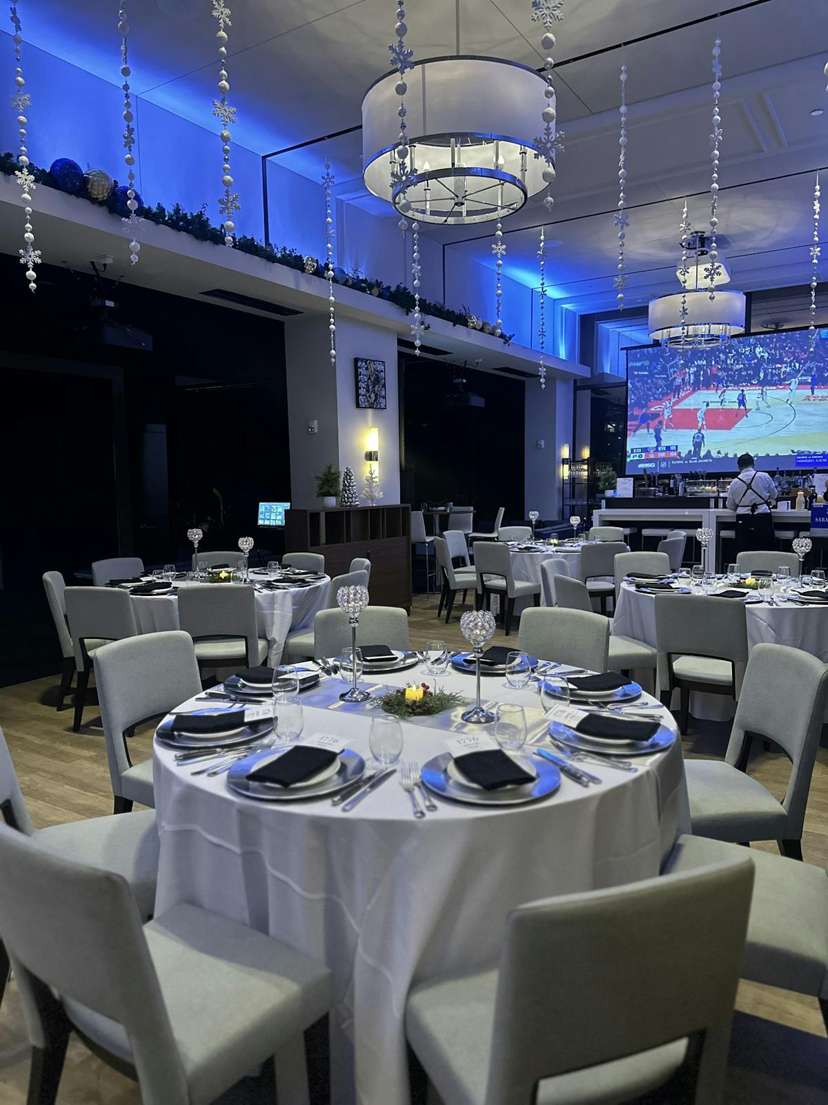 A spacious room arranged with tables and chairs, elegantly set up for a festive party atmosphere.